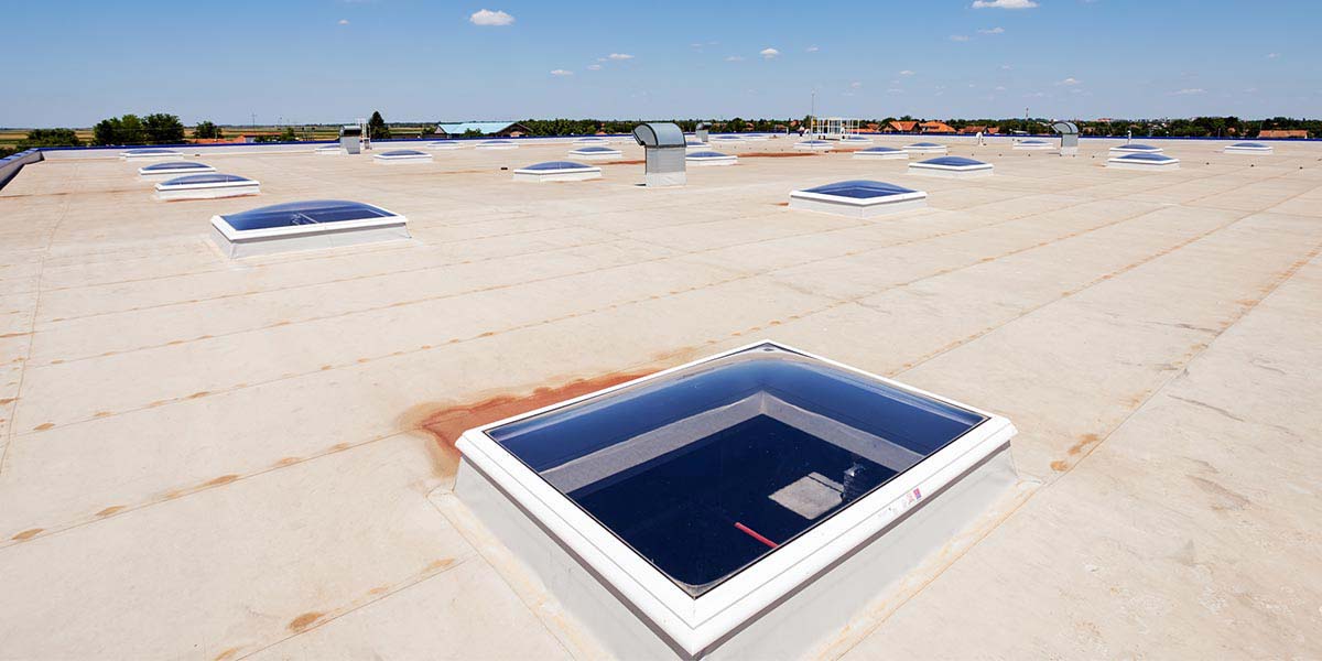 Flat Roof of an Industrial Building Under a Blue Sky.