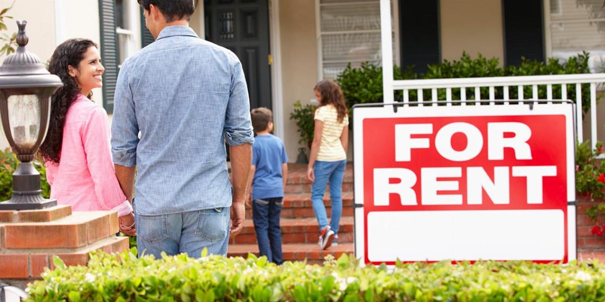 Family of four walking into home with for rent sign